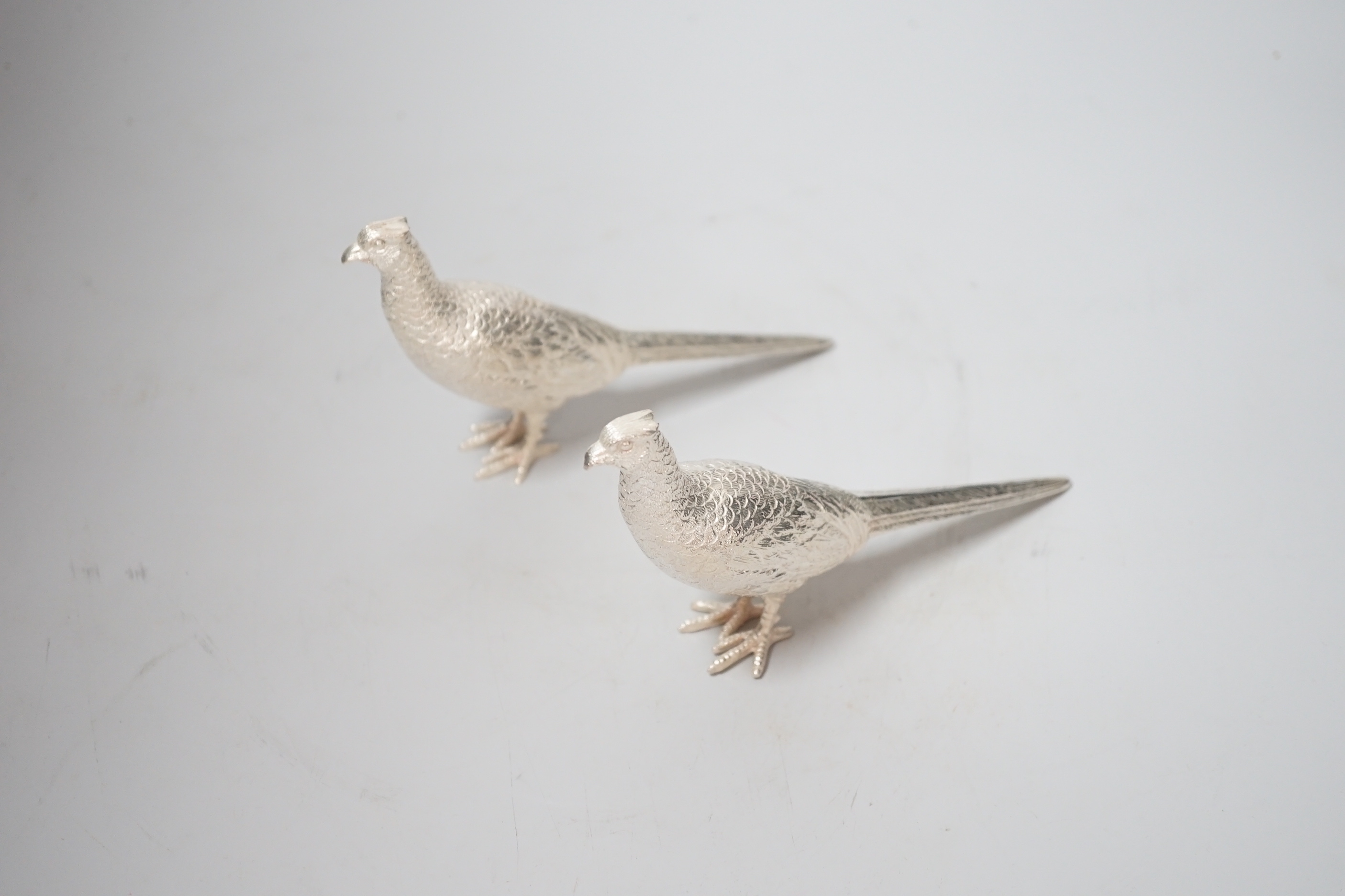 A pair of Elizabeth II silver model free-standing pheasants, by Albert Edward Jones, London, 1973, length 16cm, 9.6oz.